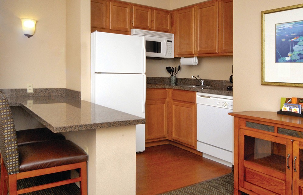 Kitchen with breakfast bar, fridge, sink, microwave, and dishwasher